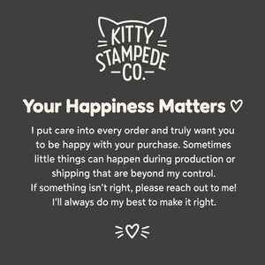 Puede incluir: Una tarjeta informativa de color gris oscuro con el logotipo de texto blanco Kitty Stampede Co. y orejas de gato encima. La tarjeta dice: Your Happiness Matters, seguido de un mensaje sobre atenci&oacute;n al cliente, producci&oacute;n, env&iacute;o y contacto.