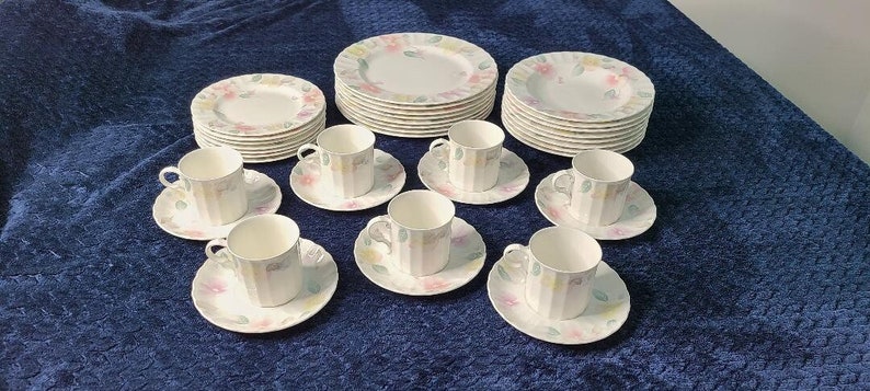 May include: A set of white teacups and saucers with a floral pattern. The set includes 8 teacups and 8 saucers.