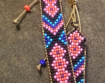 hand beaded adjustable bracelet in black,  blue,  red and pink