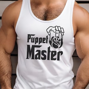 May include: White tank top with a black graphic that says "Puppet Master" with a rose and a hand holding the rose.