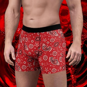 Puede incluir: Bóxers rojos con un estampado paisley blanco.