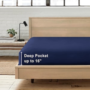 May include: A navy blue fitted sheet with a deep pocket up to 16 inches. The sheet is on a wooden bed frame.