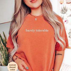 a woman wearing a t - shirt that says barely tolerable