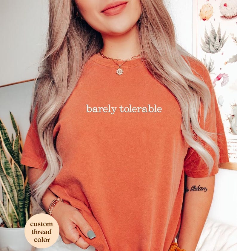 a woman wearing a t - shirt that says barely tolerable