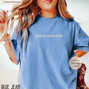 a woman wearing a blue t - shirt with a message on it