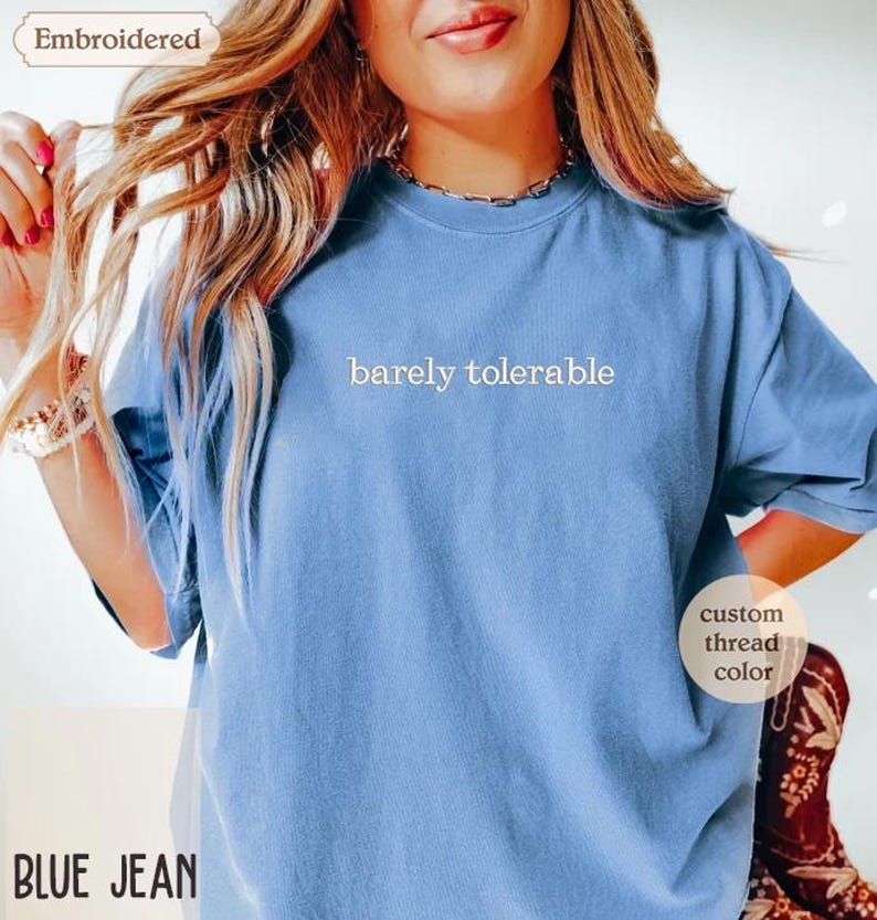 a woman wearing a blue t - shirt with a message on it