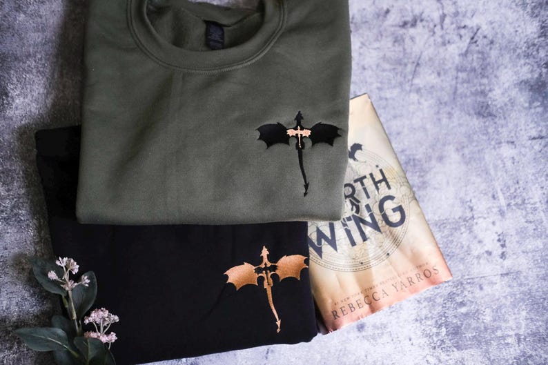 a green shirt with a bat on it next to a book