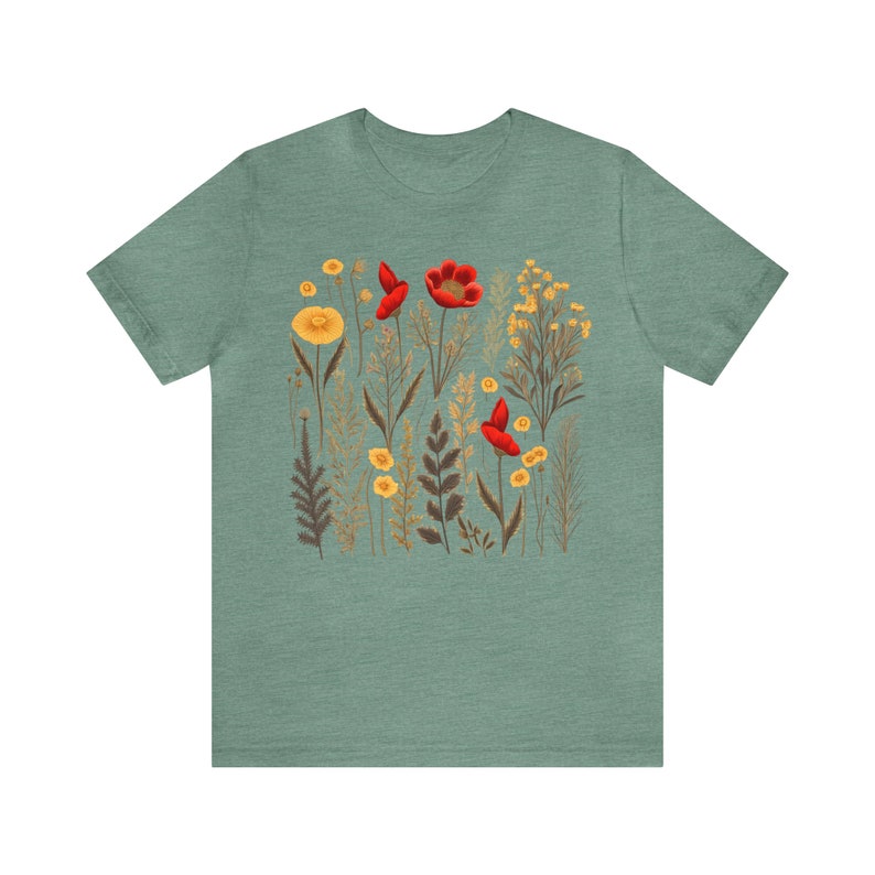 May include: A teal blue t-shirt with a floral print featuring red poppies and yellow wildflowers.