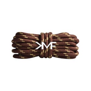 May include: Brown and tan shoelaces, tightly coiled and secured with a matching band. The laces feature a repeating pattern and a white logo in the center. The shoelaces are a neutral color and would complement a variety of shoes.