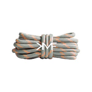 Puede incluir: Un paquete de cordones grises y naranjas con las letras blancas "KM" en el centro. Los cordones están enrollados y parecen estar hechos de un material tejido duradero. Los acentos naranjas añaden un toque de color sobre el gris.