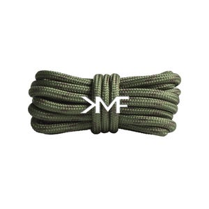 May include: A bundle of olive green rope with a camouflage pattern. The rope is tied in the middle with a matching section of rope, and the white letters "KMF" are centered on the rope.