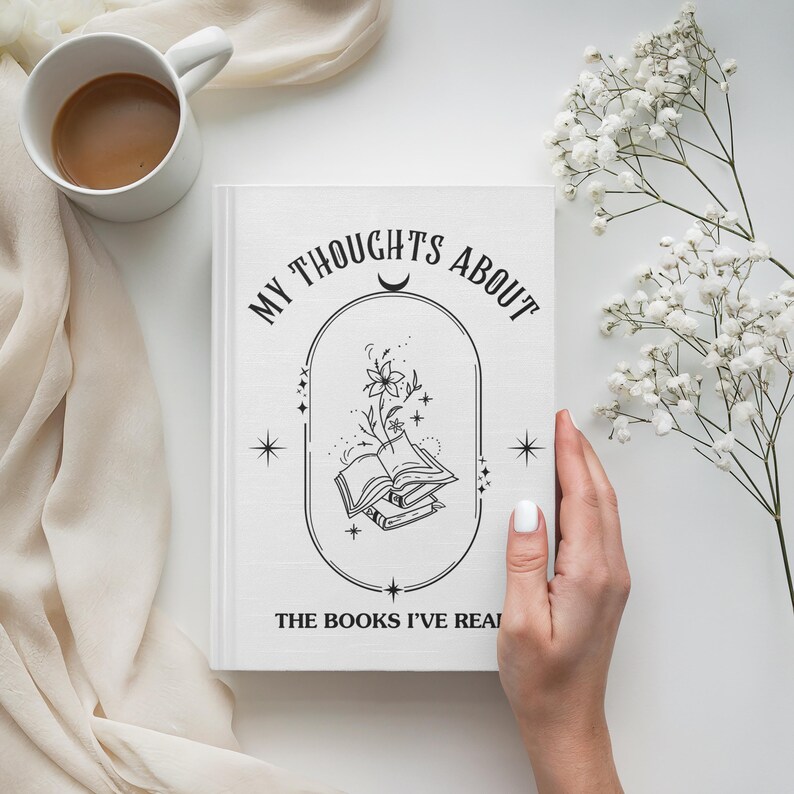 Peut inclure: Un journal blanc avec le texte "MY THOUGHTS ABOUT THE BOOKS I'VE READ" et une illustration de livres et de fleurs. Une tasse blanche avec du caf&eacute; et des fleurs blanches sont &eacute;galement visibles.