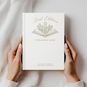 May include: A cream-colored book with the words "First Edition" and "Published 2025" in gold script. An open book illustration with floral accents is above the text. The bottom of the book reads "Special Wishes For Baby Johnson".