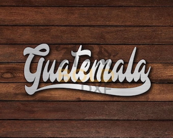 May include: A white, stylized, cursive font design of the word "Guatemala" on a brown wood background.