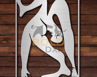 May include: A brushed metal wall art piece featuring a stylized human figure in a contorted pose within a rectangular frame. The figure is depicted in a minimalist style, with clean lines and a smooth, metallic finish. The background is a dark wood grain.