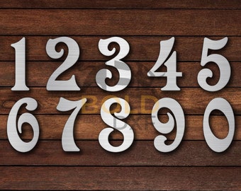 May include: Set of ten silver metal numbers, 1 through 10, on a brown wood background. The numbers are stylized and have a decorative flourish.