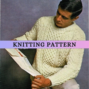 Op de afbeelding: Een witte gebreide trui met een kabelbreipatroon. De trui wordt gedragen door een persoon die een vel papier vasthoudt. De tekst "KNITTING PATTERN" is zichtbaar bovenaan de afbeelding.