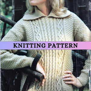 Puede incluir: Un suéter tejido de color beige con cuello y detalles de punto trenzado. La imagen presenta el texto "KNITTING PATTERN" en el centro. El suéter tiene una apariencia texturizada y probablemente está hecho de lana o un hilo similar.