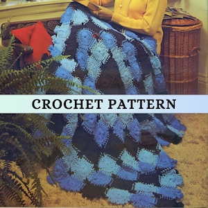 May include: A crocheted blanket in shades of blue and black, with a floral pattern. The blanket is draped over a person. The text "CROCHET PATTERN" is displayed on the image.