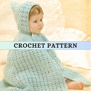 Puede incluir: Una manta de bebé con capucha de color azul claro tejida a crochet con un patrón de crochet. La manta la lleva puesta un bebé sentado sobre una superficie blanca. CROCHET PATTERN está escrito en negro sobre una pancarta azul claro.