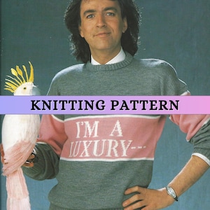 Puede incluir: Un hombre con un suéter gris con detalles en rosa y blanco. El suéter tiene el texto "I'M A LUXURY--" en el pecho. Un loro blanco con plumas amarillas en la cresta está posado en su brazo. La imagen tiene el texto "KNITTING PATTERN".