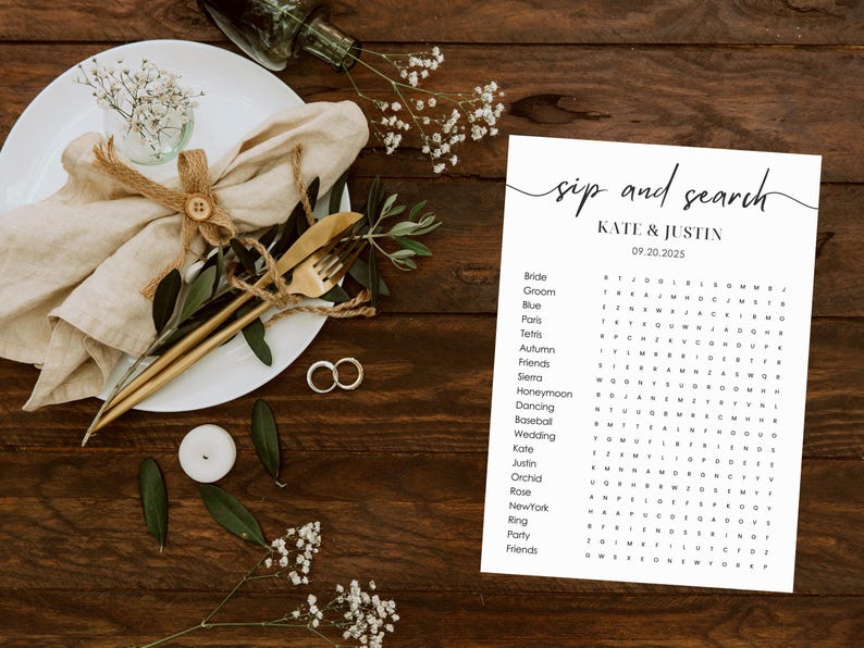 Sip and search wedding word search puzzle displayed on rustic wooden table with linen napkin, gold cutlery, wedding rings, eucalyptus and baby's breath flowers