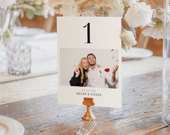 Puede incluir: Tarjeta blanca con una foto de una pareja sonriendo y tomándose de la mano. La tarjeta tiene el número "1" impreso en negro en la parte superior y el texto "09.10.2024 MEGAN & STEVEN" impreso en la parte inferior.