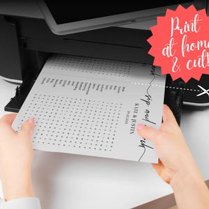 Hands pulling printed sip and search wedding word search puzzle from home printer, print at home and cut, instant download printable template