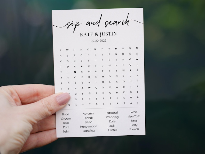 Minimalist sip and search wedding word search puzzle card held in hand, couple names and date at top, custom words listed in four columns below the grid