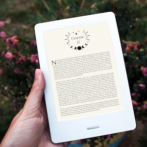 Puede incluir: Un lector electrónico blanco con una imagen en blanco y negro de una luna creciente y estrellas. El texto en la pantalla dice "Capítulo 17".