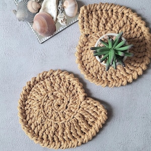 May include: A white ceramic mug with a black handle and the text "But First, Coffee" in a bold, black font. The mug is set against a blurred background, highlighting its clean design.