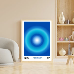 May include: A blue and white abstract art print with a circle in the center and the text "LUCK" and "Wonderful things are about to happen. Keep yourself open to receive what you deserve. 777" at the bottom.