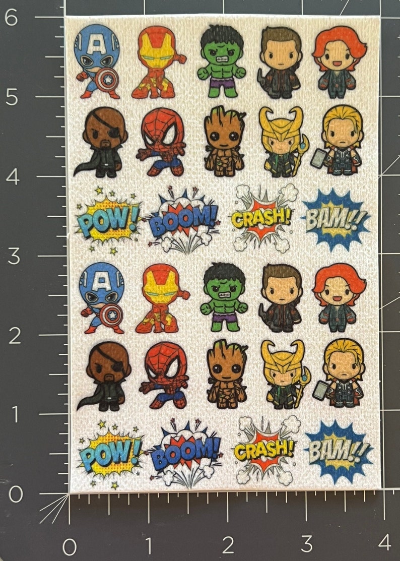 Op de afbeelding: Een vel stickers met verschillende Marvel-personages, waaronder Captain America, Iron Man, Hulk, Thor, Loki en Groot. De stickers zijn in cartoon-stijl en hebben een glanzende afwerking. Het vel bevat ook geluidseffect-stickers met de woorden "POW!", "BOOM!", "CRASH!" en "BAM!"