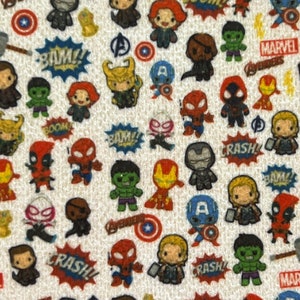 Op de afbeelding: Een witte stof met een herhalend patroon van cartoon superhelden uit het Marvel-universum. De personages omvatten Iron Man, Captain America, Thor, Hulk, Spider-Man, Black Widow en Deadpool. De stof bevat ook de woorden "BOOM!" "BAM!" en "CRASH!" in een comic-boek lettertype.