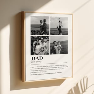 May include: Framed black and white print featuring four family photos. The word "DAD" is prominently displayed with a definition below. The print is in a light wood frame and hangs on a neutral wall.