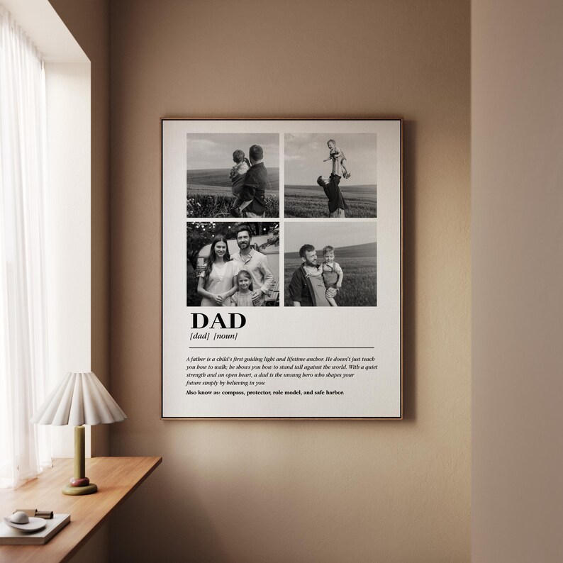 May include: Framed black and white print featuring four family photos. The word "DAD" is centered at the bottom, with a definition and a quote about fatherhood. The print is displayed on a wall next to a window with a lamp.