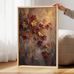 May include: A rectangular framed wall art piece featuring an oil painting of autumn maple leaves in shades of red, orange, and yellow. The leaves are attached to thin branches against a textured, neutral-toned background with visible brushstrokes.