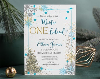 May include: A white invitation card with a blue and gold snowflake design. The text on the card reads "You are invited to our Winter One derland. Our little snowflake Ethan James is turning one. December 22nd | 1:00 PM. 1234 Street City In, Anywhere St 54321. RSVP to Sophia @ 123.456.7890."
