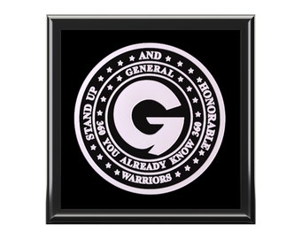 May include: A black and white circular graphic with the letter "G" in the center. The graphic is surrounded by a circle with the text "Stand Up And General 360 You Already Know 360 Honorable Warriors".