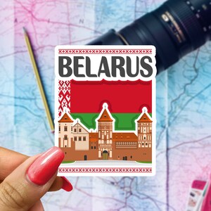 May include: A rectangular sticker featuring the word "BELARUS" in bold white letters. The sticker showcases a red and green flag design, along with an illustration of a castle. The sticker is held by a hand with red nail polish.