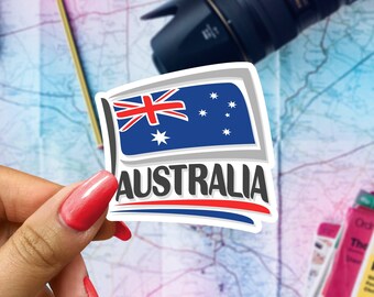 May include: A sticker featuring the Australian flag with the word "AUSTRALIA" in bold, red letters. The flag is blue, white, and red with a white star in the center and five white stars in the upper right corner.