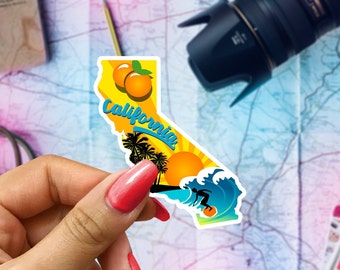 May include: A yellow and blue sticker shaped like the state of California with the word "California" in blue cursive lettering, two orange oranges, palm trees, a setting sun, and a surfer riding a wave.