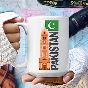 May include: White ceramic mug with a graphic of a building and the Pakistani flag. The text "PAKISTAN" is printed vertically on the mug.
