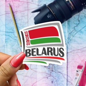 May include: A white sticker with a red and green flag and the word "BELARUS" in black letters. The flag has a white pattern on the red portion.