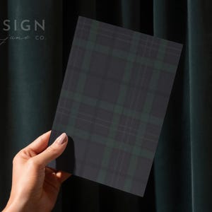 May include: A rectangular card featuring a dark charcoal gray and forest green plaid pattern. The text DESIGN june co. is printed in the upper left corner of the card. The card has a smooth, matte finish and sharp, clean edges.