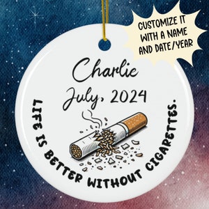 May include: White ceramic ornament with a broken cigarette and the text "Life is better without cigarettes."  The ornament is personalized with the name "Charlie" and the date "July, 2024".