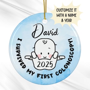 May include: A round, light blue ceramic ornament with a gold string for hanging. The ornament features the name "David" above a cartoon baby illustration. Text includes "I SURVIVED MY FIRST COLONOSCOPY!" and the year "2025".
