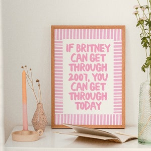 K&ouml;nnte beinhalten: Ein gerahmter Druck mit rosa und wei&szlig;en Streifen und dem Text "Wenn Britney 2007 &uuml;berstehen konnte, kannst du auch heute durchhalten."