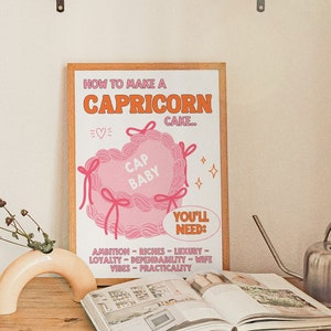 May include: A pink and orange illustrated poster with the text "How to make a Capricorn cake."  The poster features a pink heart-shaped cake with the text "Cap Baby" inside. The poster also includes a list of ingredients needed to make the cake, including ambition, riches, luxury, loyalty, dependability, wife vibes, and practicality.