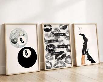 May include: Three framed art prints. The first features a disco ball and a black eight ball. The second has lipstick kiss marks with the text "oh how I love being a woman". The third shows a leg in a black boot holding a martini.